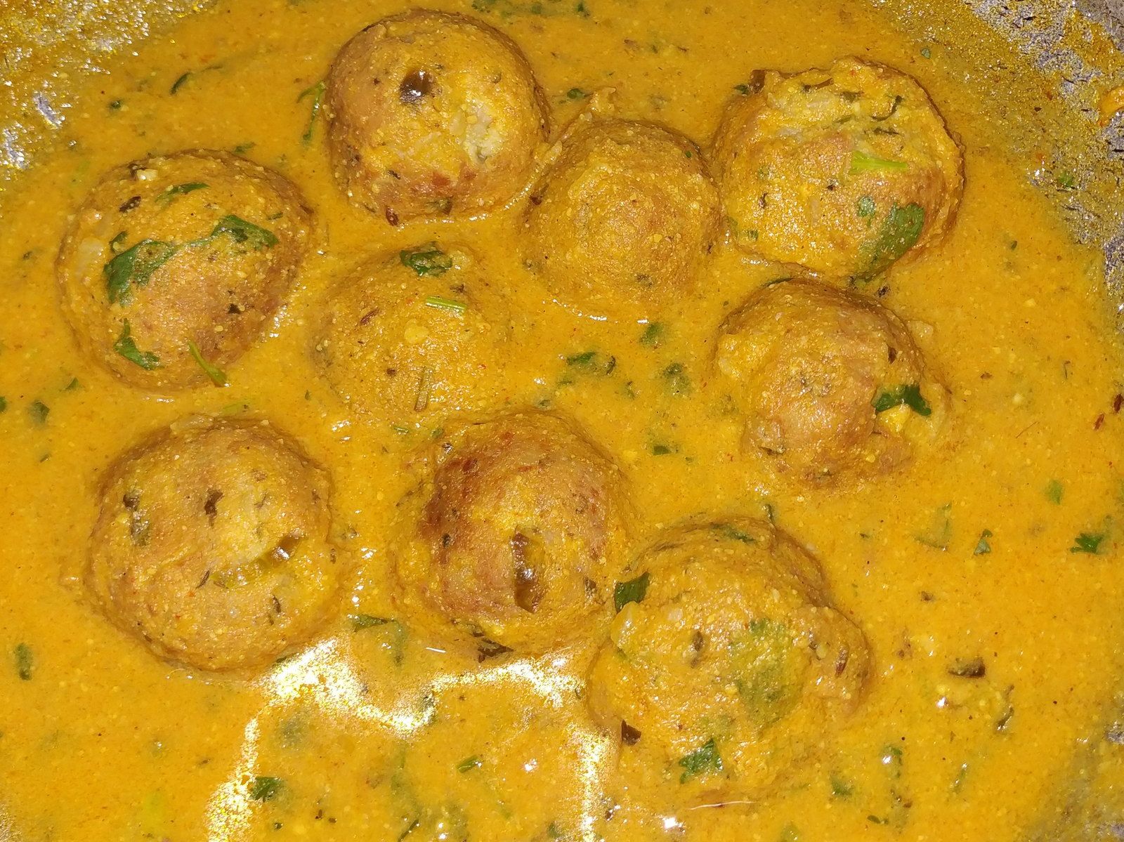 Meatballs in a golden, gently spiced sauce, scattered with coriander