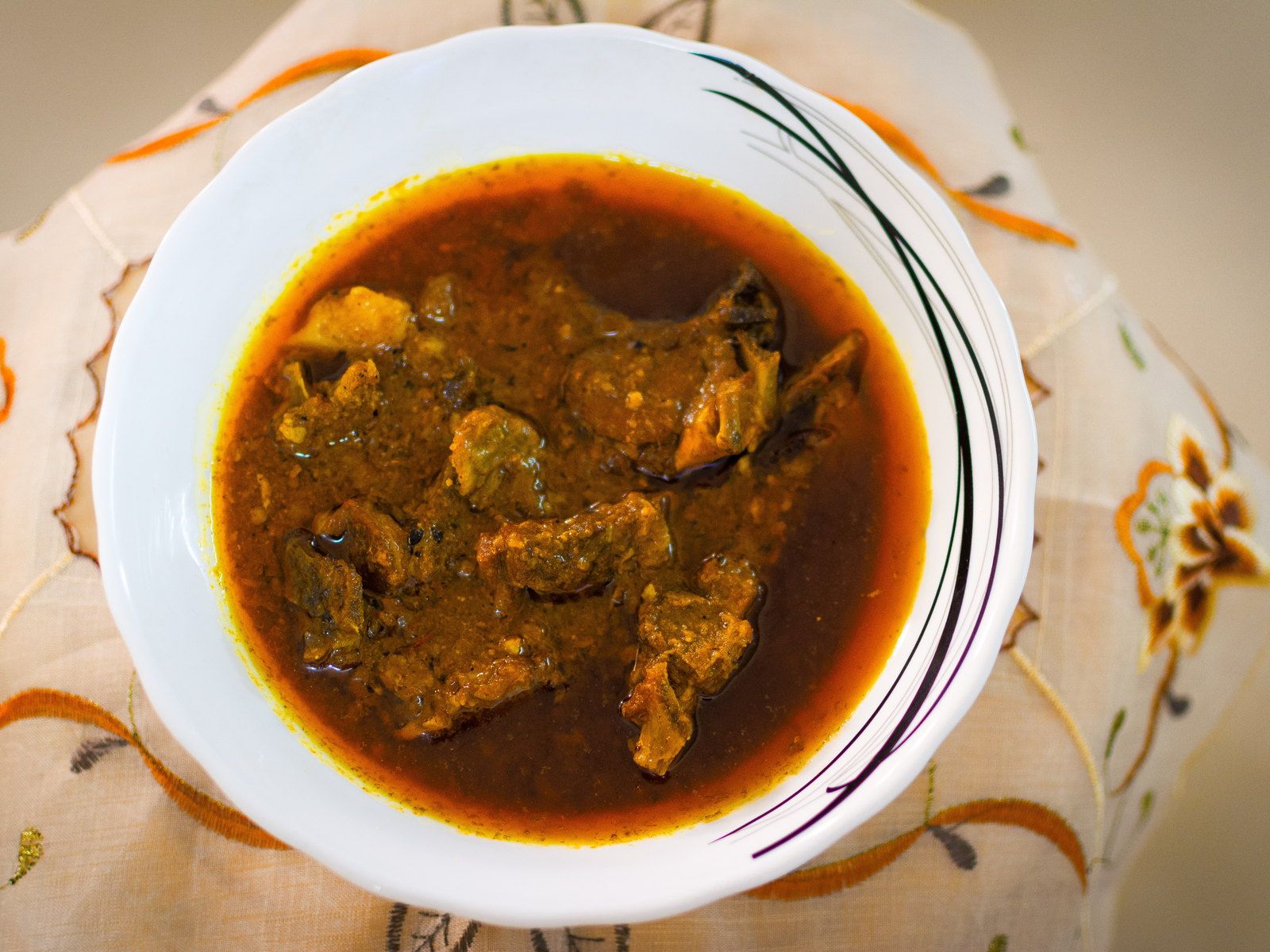 Slow-cooked lamb in a pale, nut-thickened sauce in a scalloped bowl