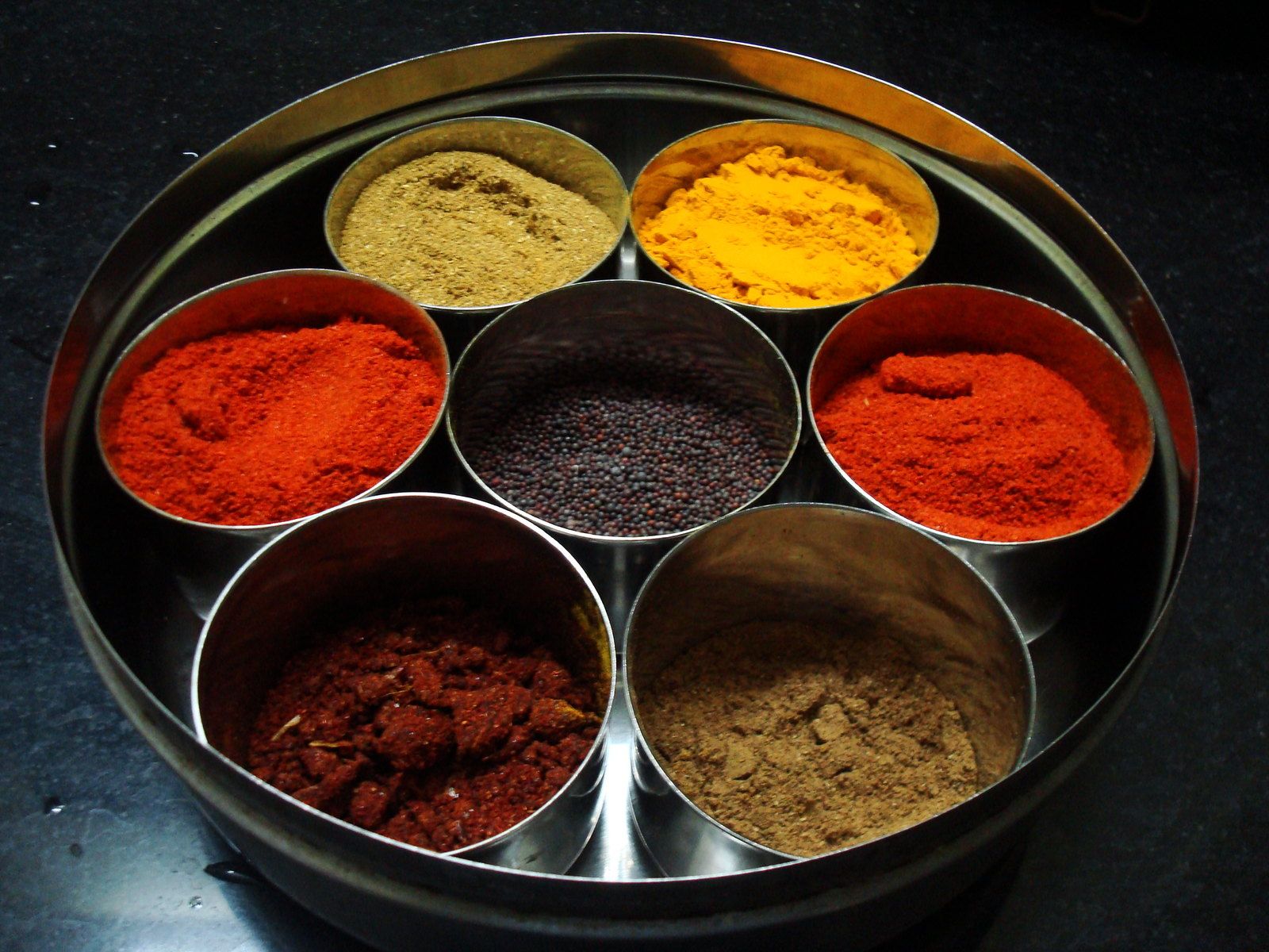A seven-well spice box photographed straight down from above